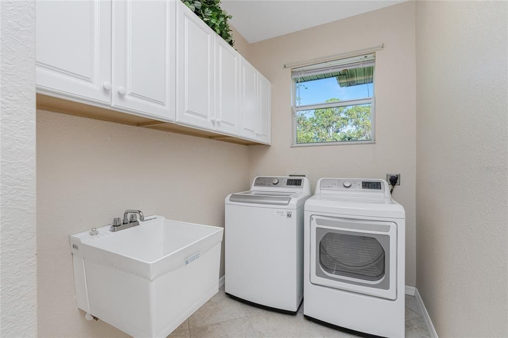 Laundry room includes washer dryer features sink & window.