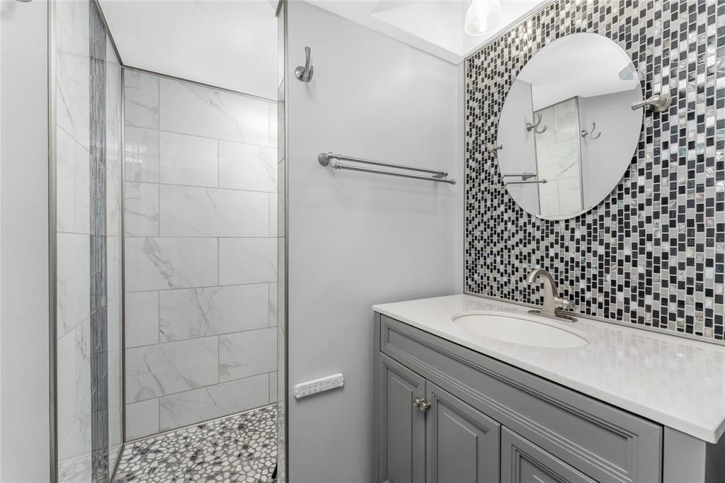 Updated Guest bath has a step in shower with glass door.