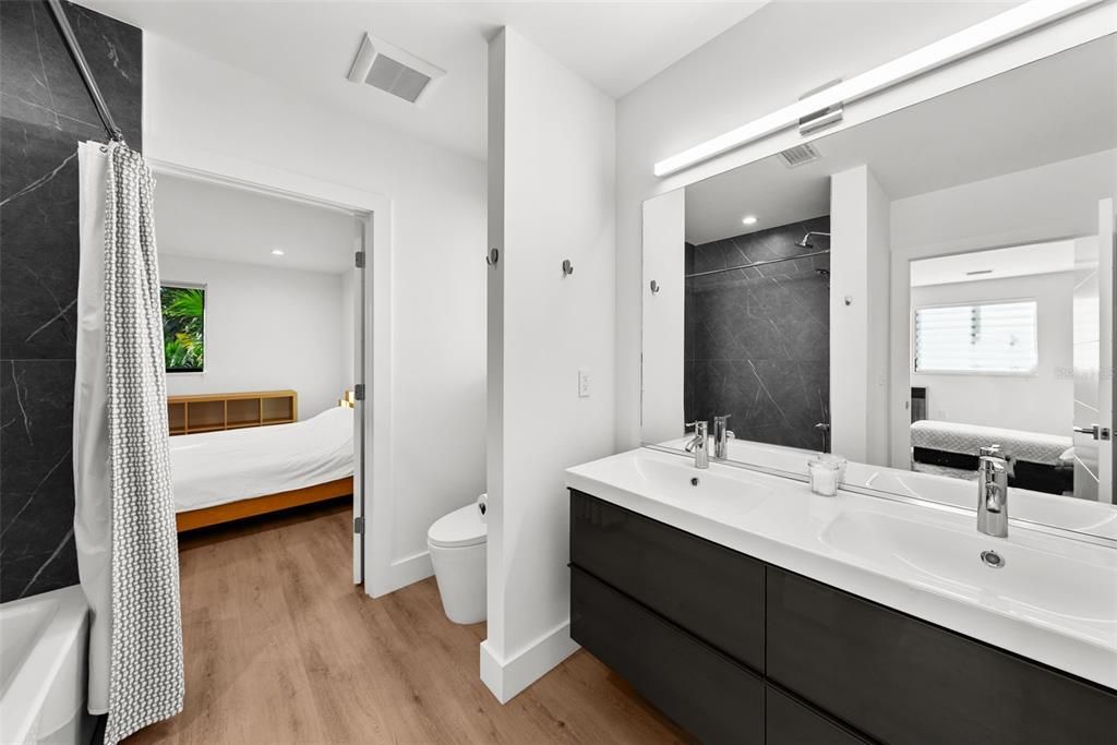 Jack and Jill bathroom with a tub/shower and two vanity sinks.