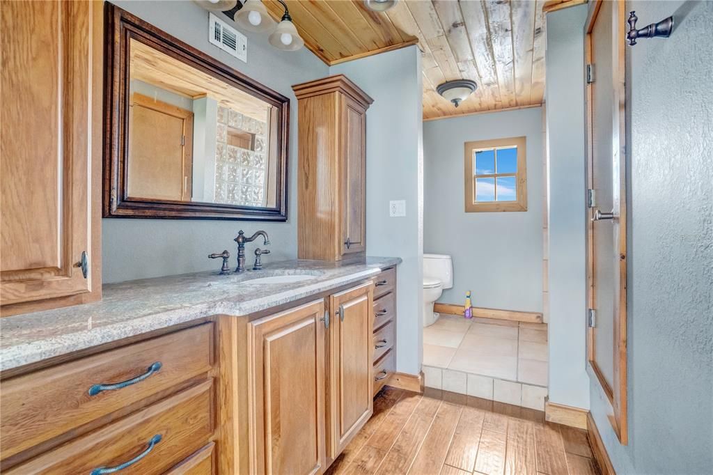 Primary bathroom featuring elegant wood cabinets that add warmth and timeless style