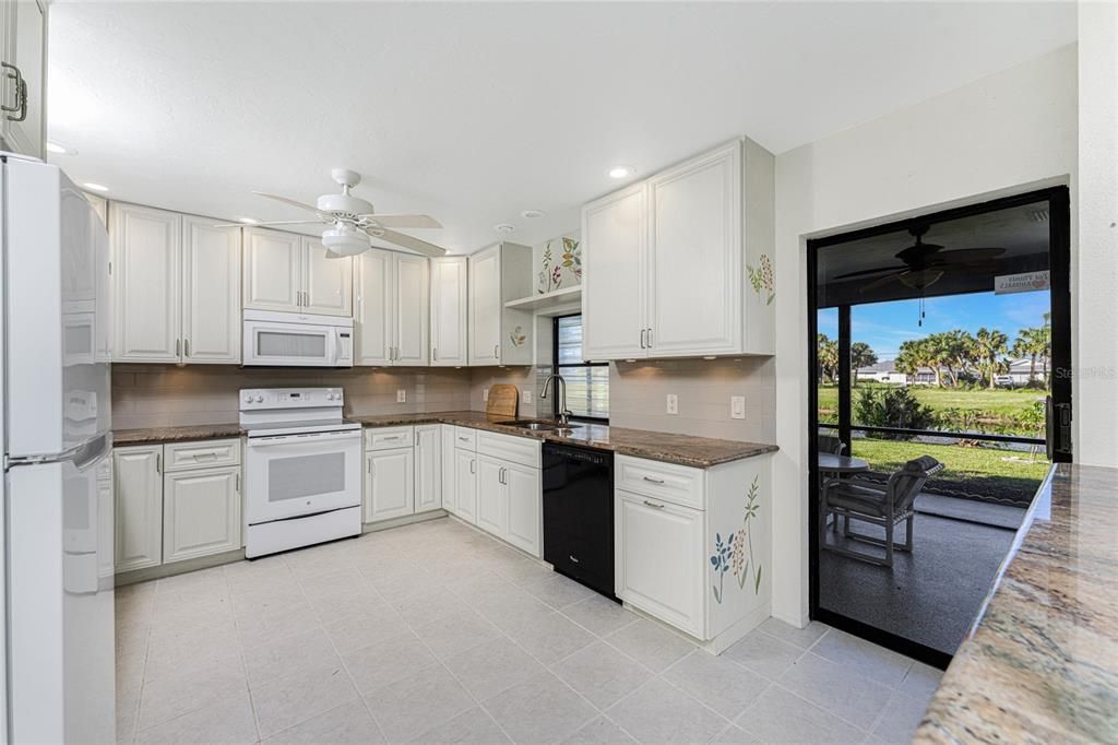 Kitchen features updated raised face cabinetry and granite countertops.