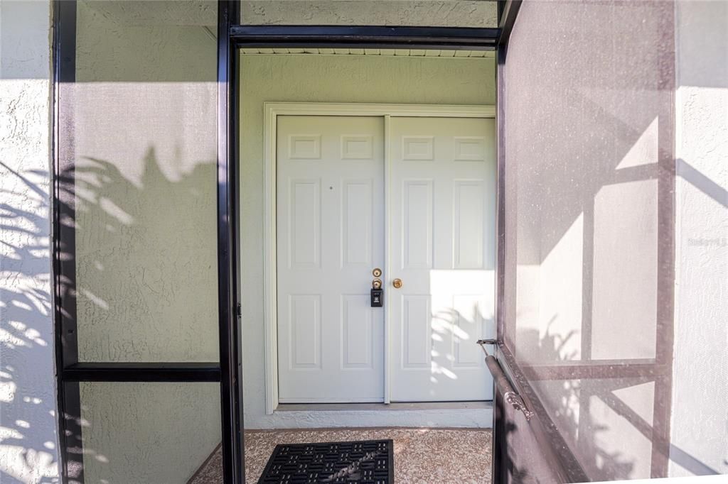 The screened entry way leads to your double doors.