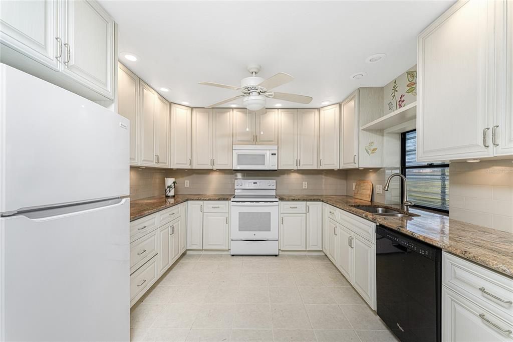 The kitchen has a Whirlpool refrigerator, Whirlpool microwave, GE smooth top stove and Whirlpool dishwasher.