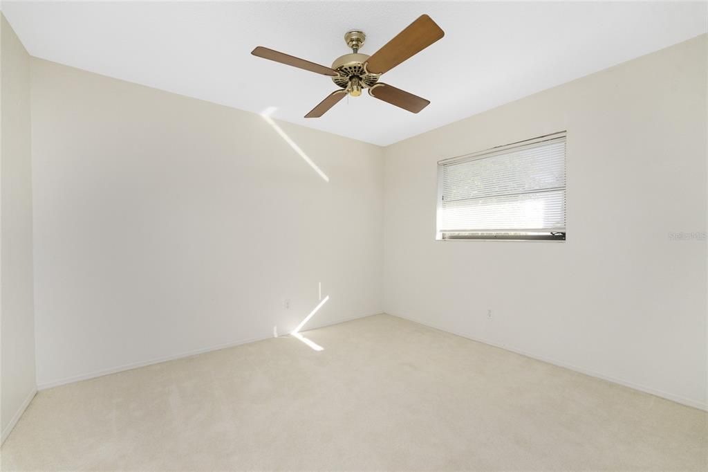 Bedroom #2 has carpeted flooring and a ceiling fan.