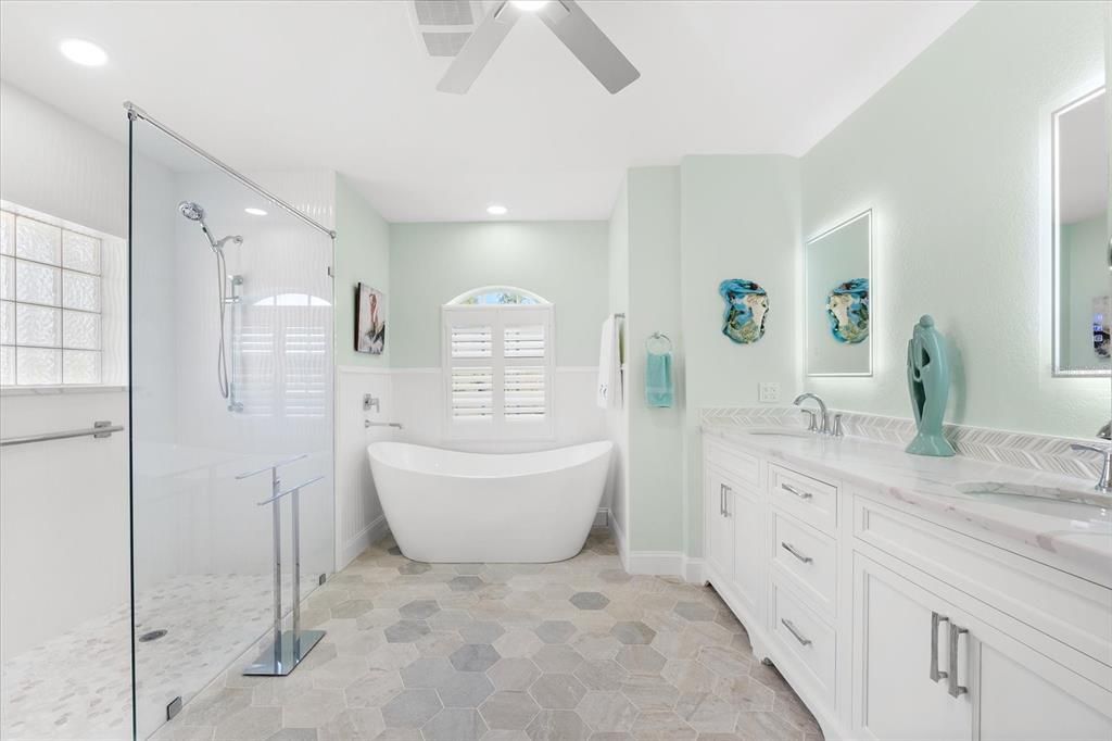 The ensuite has a soaking tub, a walk-in shower, and a double vanity with LED mirrors.