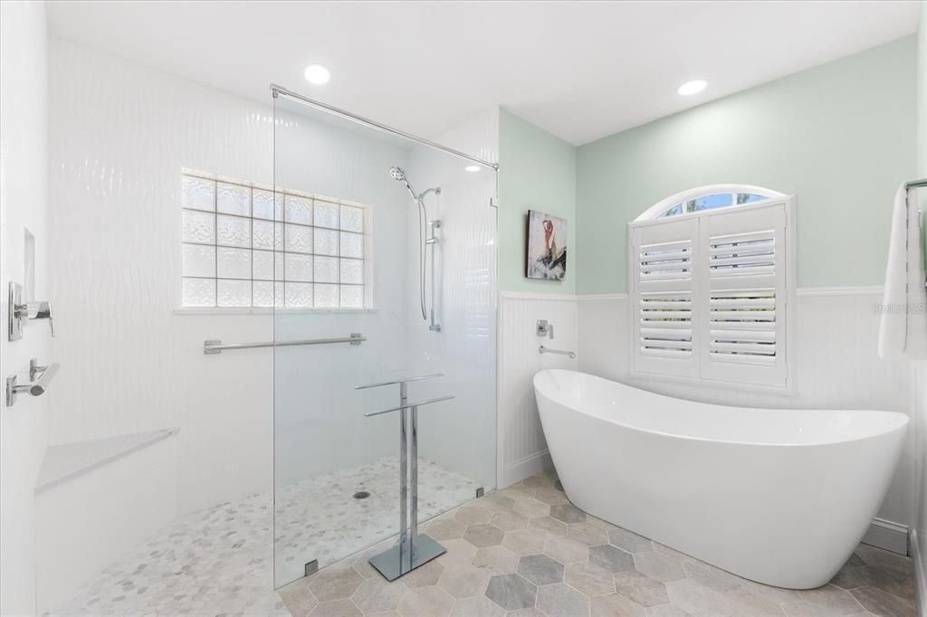 Walk-in shower with grab bar and shelf seating.