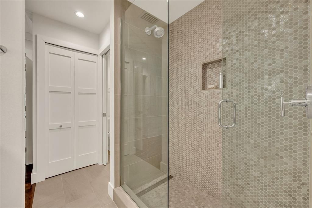 Glass front shower with hexagonal tile feature wall