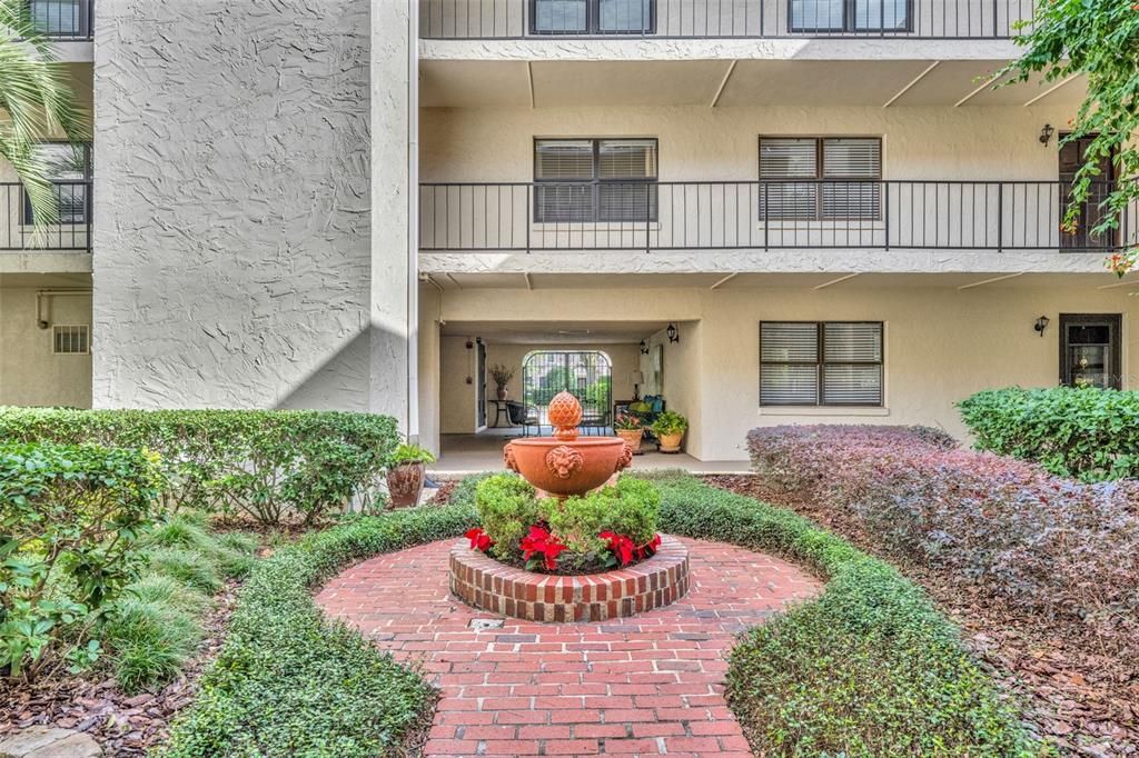 Entry Courtyard, lushly landscaped with center fountain.