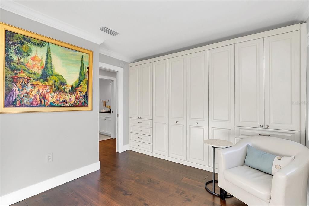 Guest room offers a wall of built-ins with wardrobe storage and queen size Murphy bed