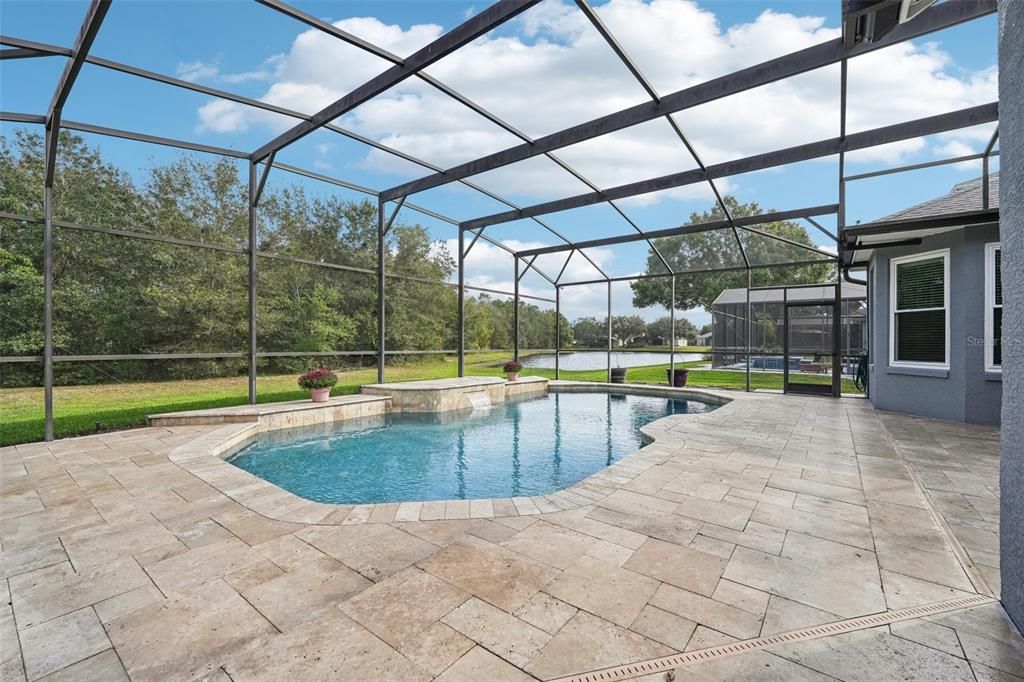 Spacious under screen pool that has PebbleTec surface & a travertine tile pool deck!