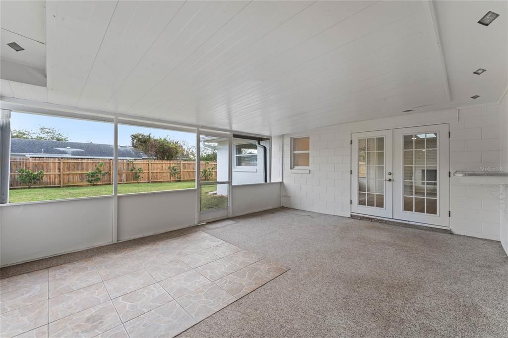 Spacious back porch is covered, screened and has beautiful views of the backyard