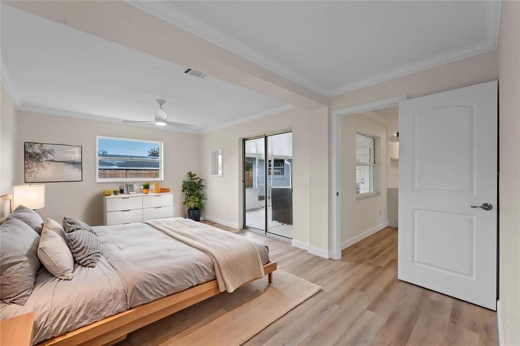 Primary bedroom features sliding doors out to the screened-in patio and a large walk-in closet