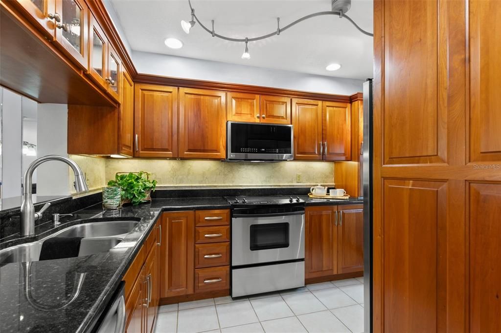 Beautiful upgraded kitchen with custom solid wood cherry cabinets that are 13-inches deep and stainless steel appliances