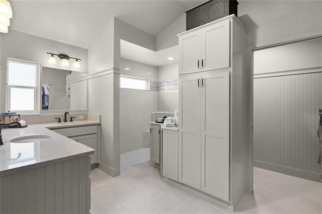 WHAT A BEAUTIFUL BATH WITH DUAL SINKS, QUARTZ COUNTERS, AND CUSTOM CABINETS.