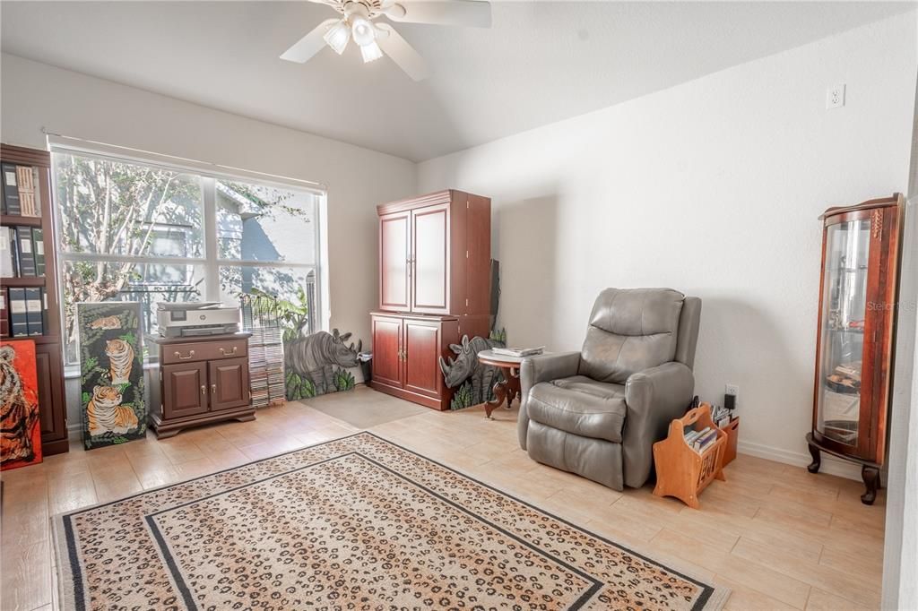 The 3rd bedroom features neutral tones, ceramic tile flooring, a ceiling fan with light kit, and a built-in closet.