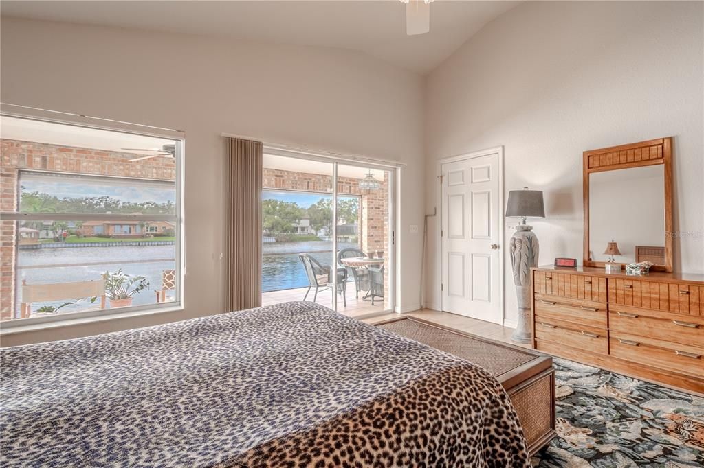 The primary bedroom features lake views with sliding glass doors to the lanai.