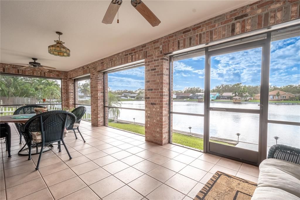 The screened in lanai with electric shades, a ceramic tile floor, ceiling fans brings the outside in for year-round enjoyment.