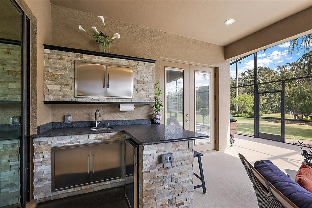 The outdoor kitchen area currently has a mini-fridge and storage. The home is plumbed, so a gas grill can be added if desired.