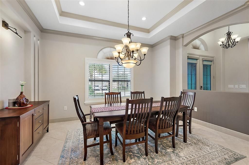 In the 14 x13 formal dining room, notice the crown molding trey ceiling and lighted art sconce.