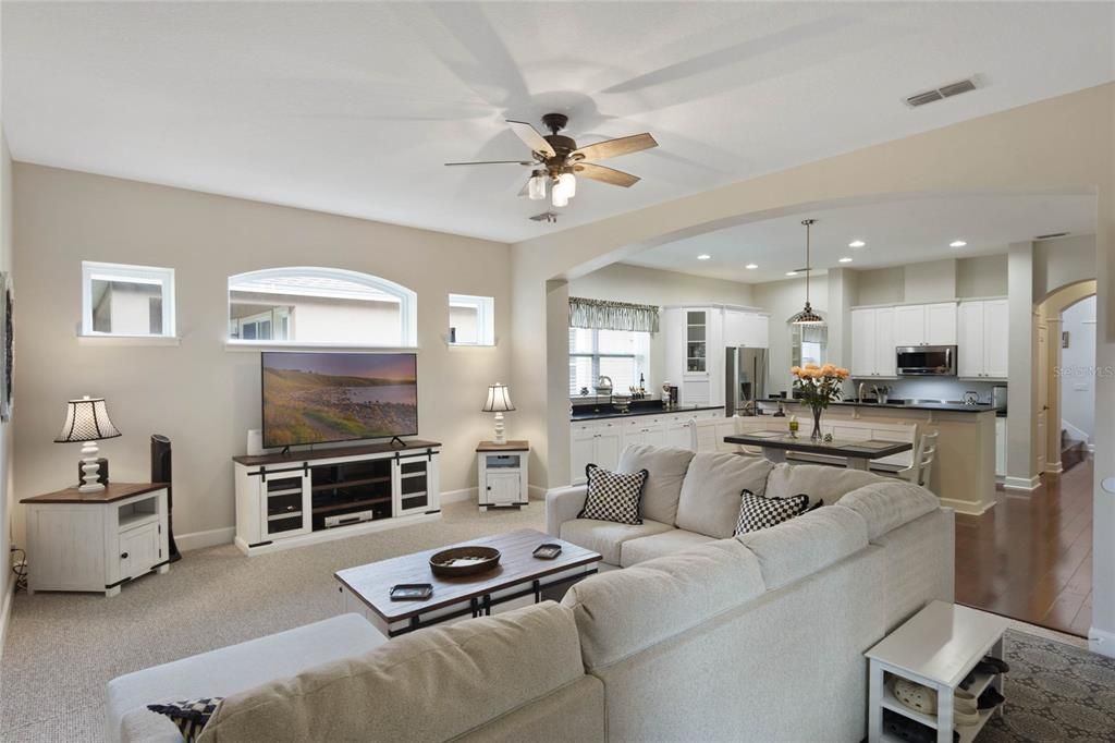 Family room featuring arched windows and openings to rooms throughout the first floor