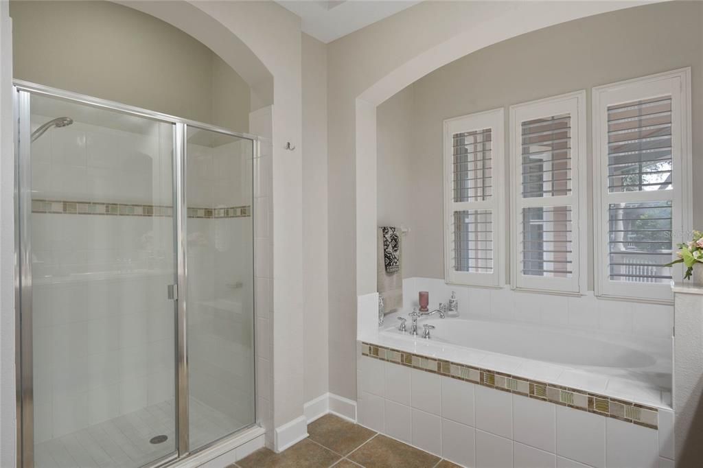 Primary bedroom ensuite bathroom, stand alone shower, and garden tub, shutters