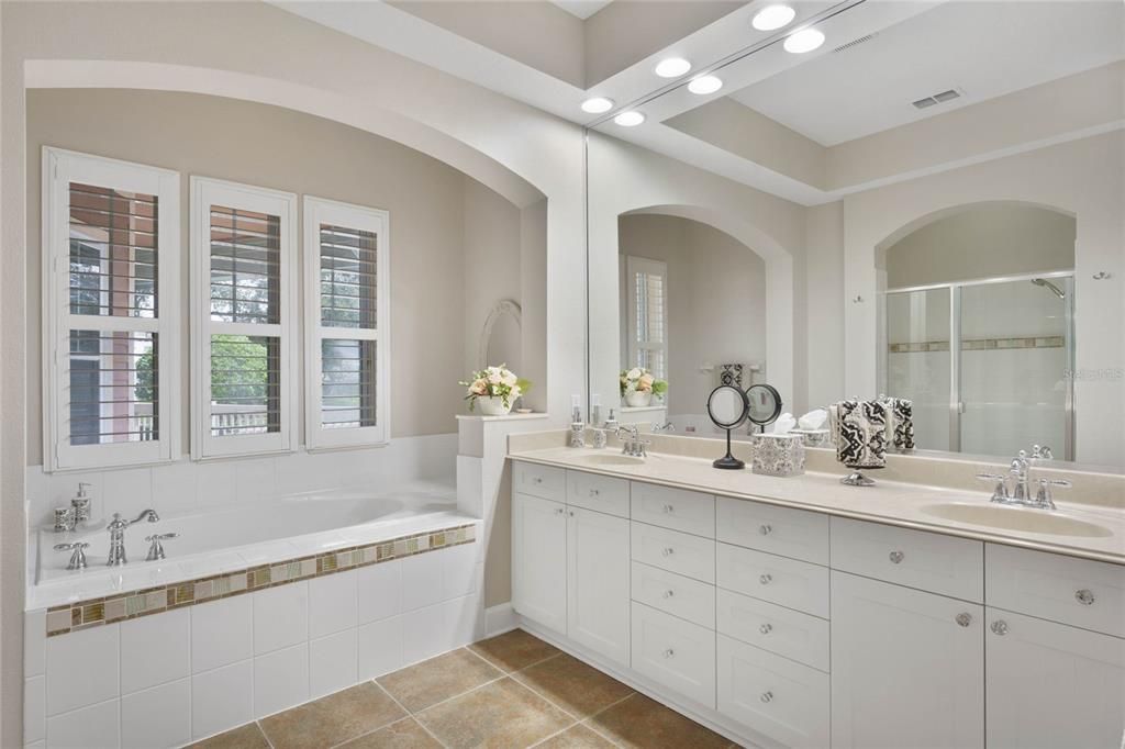 Primary bedroom ensuite bathroom, double sinks, and garden tub, and arched architectural details