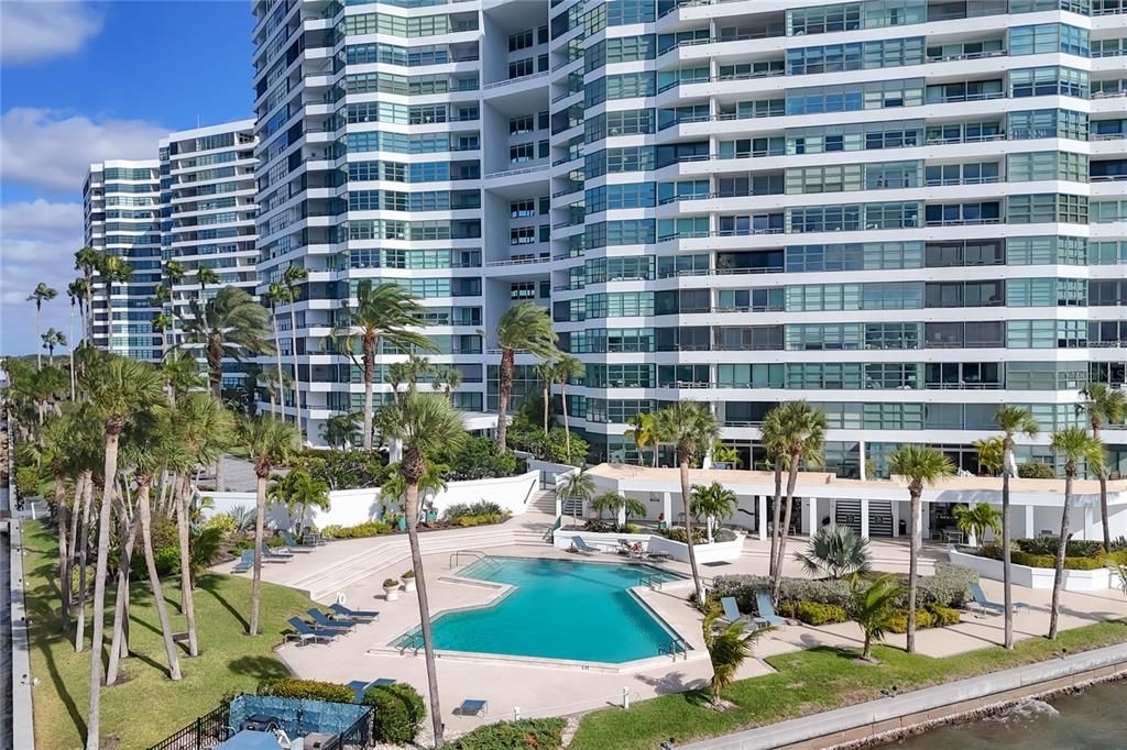 Condo on the Bay amenities featuring the community pool, lounge area, and fitness center entrance.