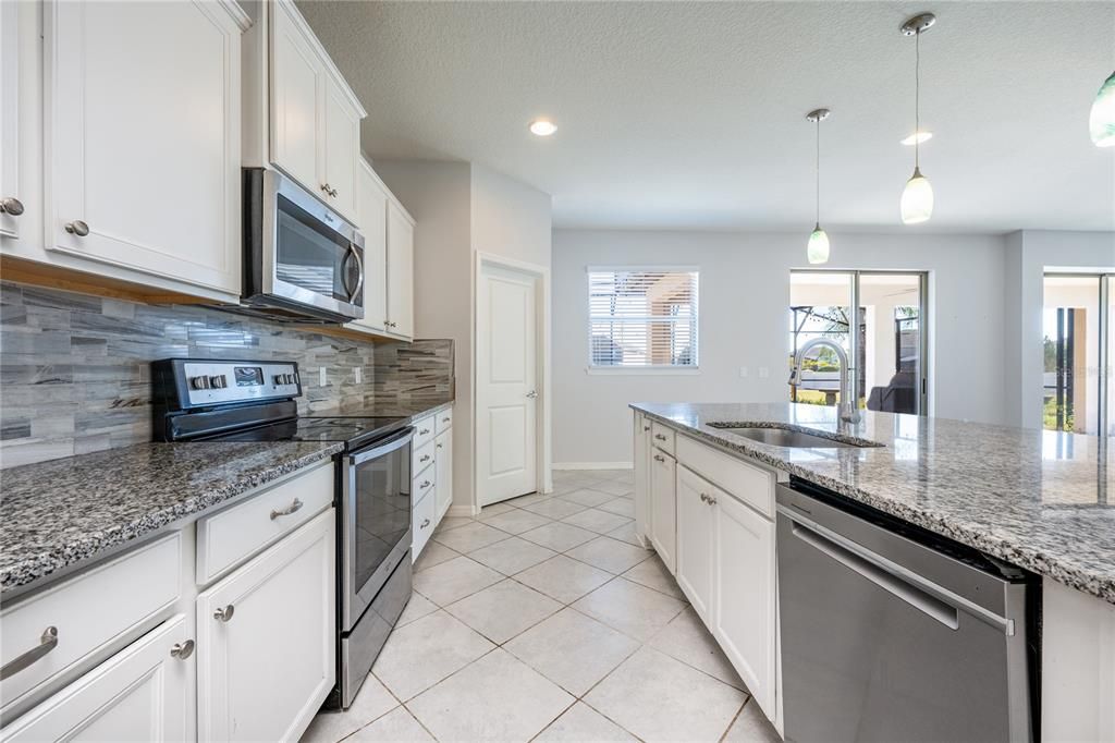 The kitchen was designed with the modern chef in mind and delivers a stylish color palette, GRANITE COUNTERS, tiled backsplash, STAINLESS STEEL APPLIANCES, breakfast bar seating on the oversized ISLAND, and all the storage space you could ask for.