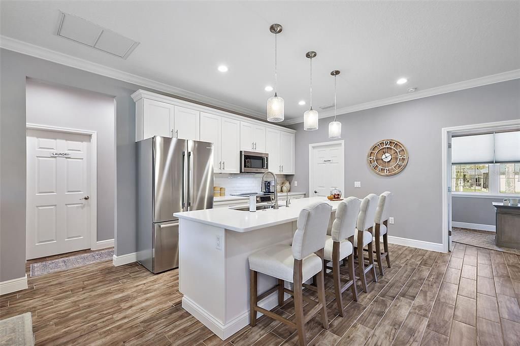 The kitchen is a dream, with Quartz countertops, SS appliances, pendant lights and an upgraded 'touchless' kitchen faucet. Note the office to the right.