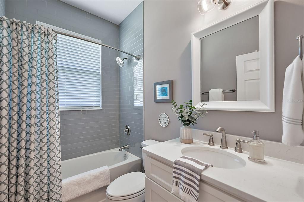 Guest/hall bathroom; Quartz vanity and glass tile shower surround