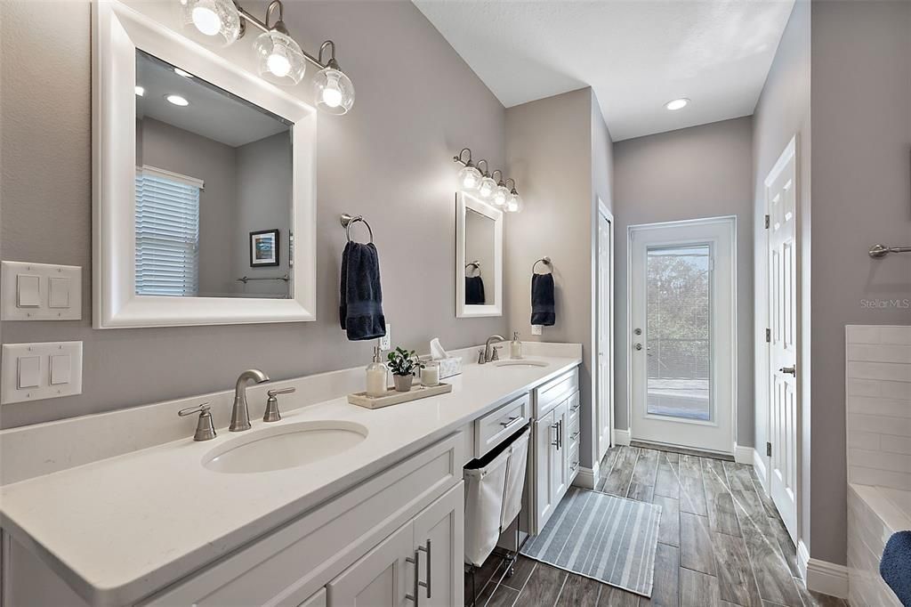 Dual Quartz topped sinks, linen closet and a convenient door to the pool