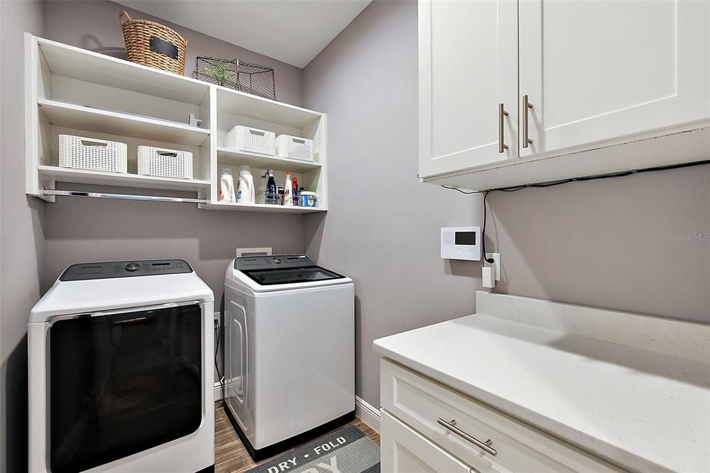 Laundry room with cabinetry and built in shelving.