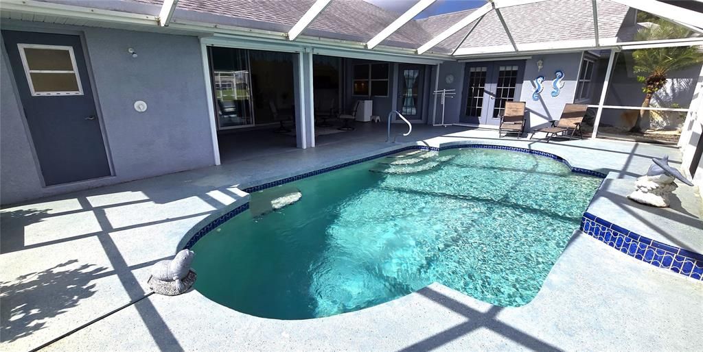 Screened waterfront pool enclosure with shower and half bath