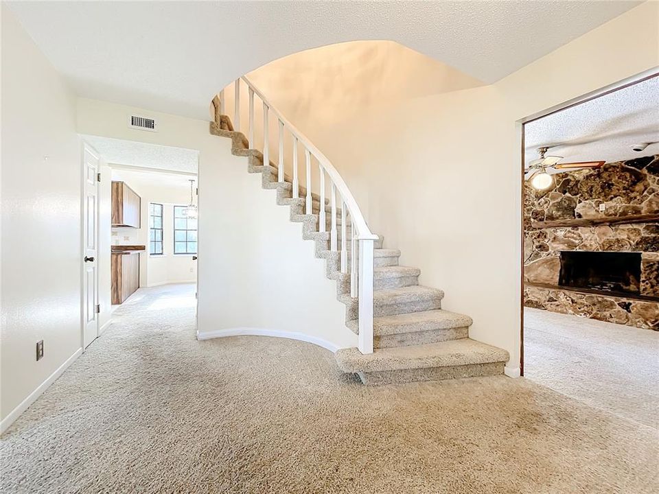 Beautiful view as you walk in front door.  Staircase leading to upstairs and large wood burning fireplace in family room.