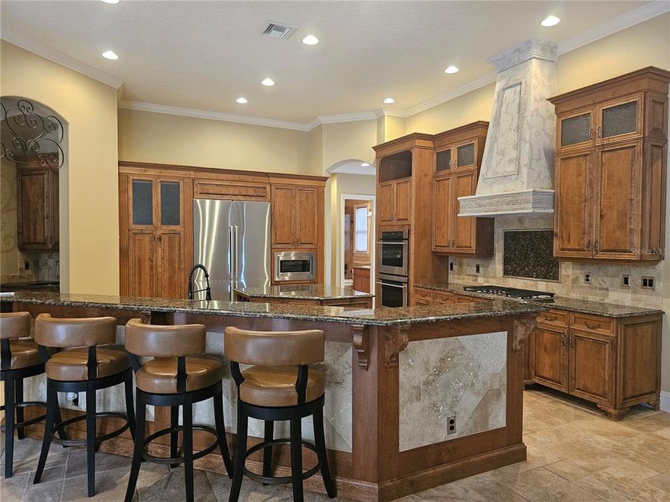 View from Breakfast nook into Gourmet Kitchen.  Cooktop was converted to gas and new stainless refrigerator and double ovens also added.