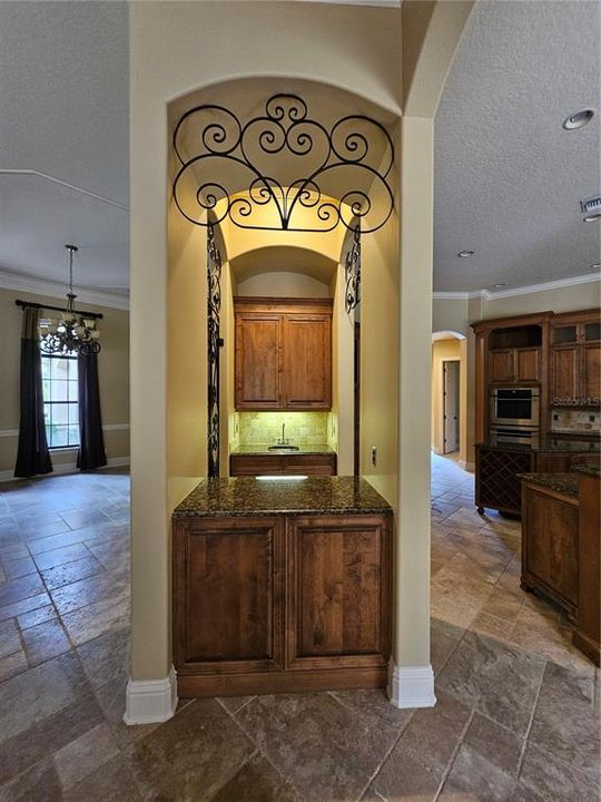 Wet Bar area with iron accents separating Formal Dining from Gourmet Kitchen