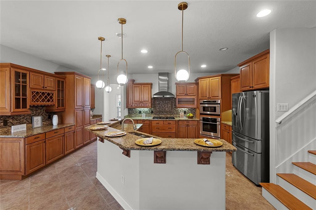 KITCHEN - MODEL HOME KITCHEN W/ CUSTOM CABINETRY, LARGE CENTER ISLAND, "BAR TOP" EATING, STAINLESS APPLIANCES & GAS COOKTOP