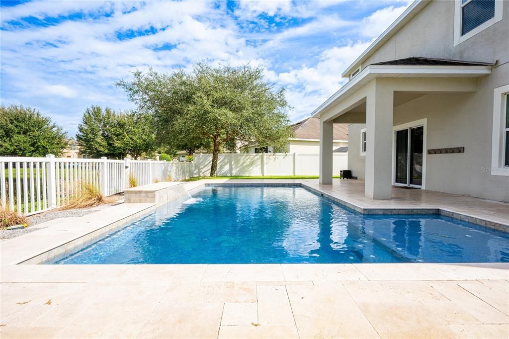 The sparkling pool is surrounded by a TRAVERTINE DECK and the COVERED PATIO gives you an ideal place to relax poolside and take advantage of the WATER VIEWS!