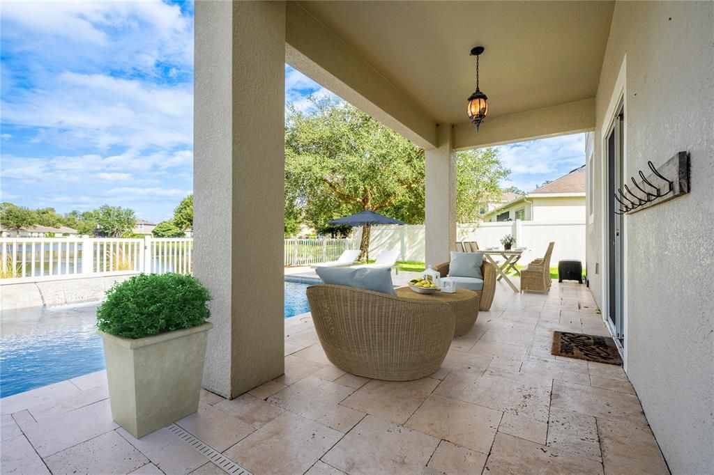 The sparkling pool is surrounded by a TRAVERTINE DECK and the COVERED PATIO gives you an ideal place to relax poolside and take advantage of the WATER VIEWS! Virtually Staged.