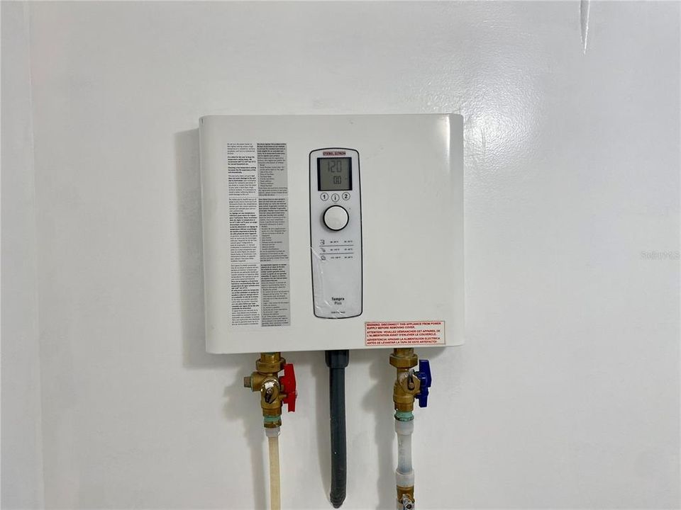 Electric Whole House Tankless Water Heater located in Laundry Room.