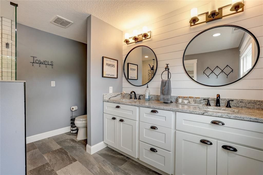 Primary en suite bath with ship lap wall and granite counters