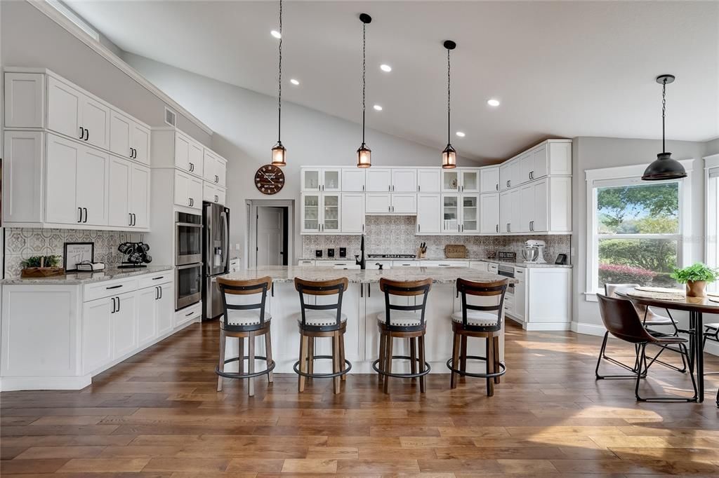 Gourmet kitchen with stainless steel appliances, breakfast bar and volume ceiling