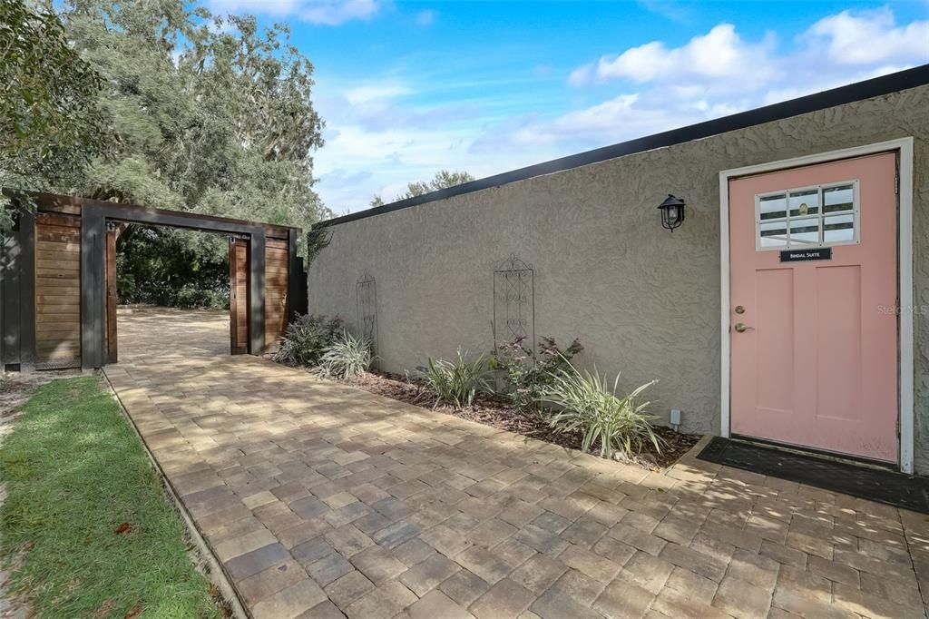 Pavered walk to wedding venue and door into garage/storage