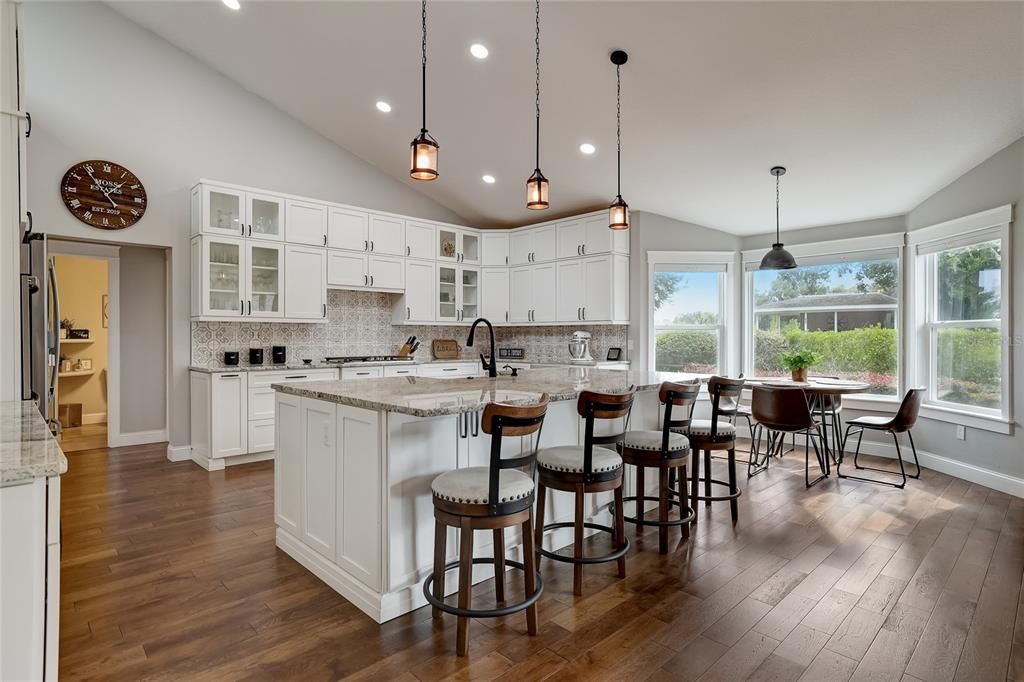 This kitchen has it all with double cabinets, double ovens, large island, vaulted ceiling and bay window.