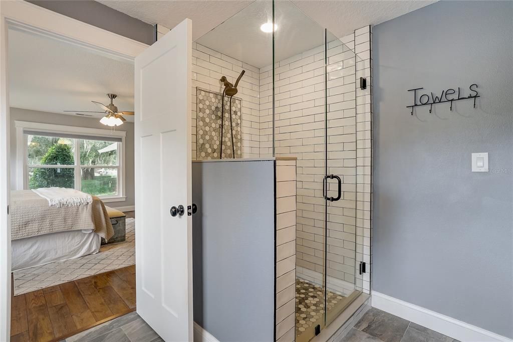 Frameless shower surround with custom tile in primary en suite