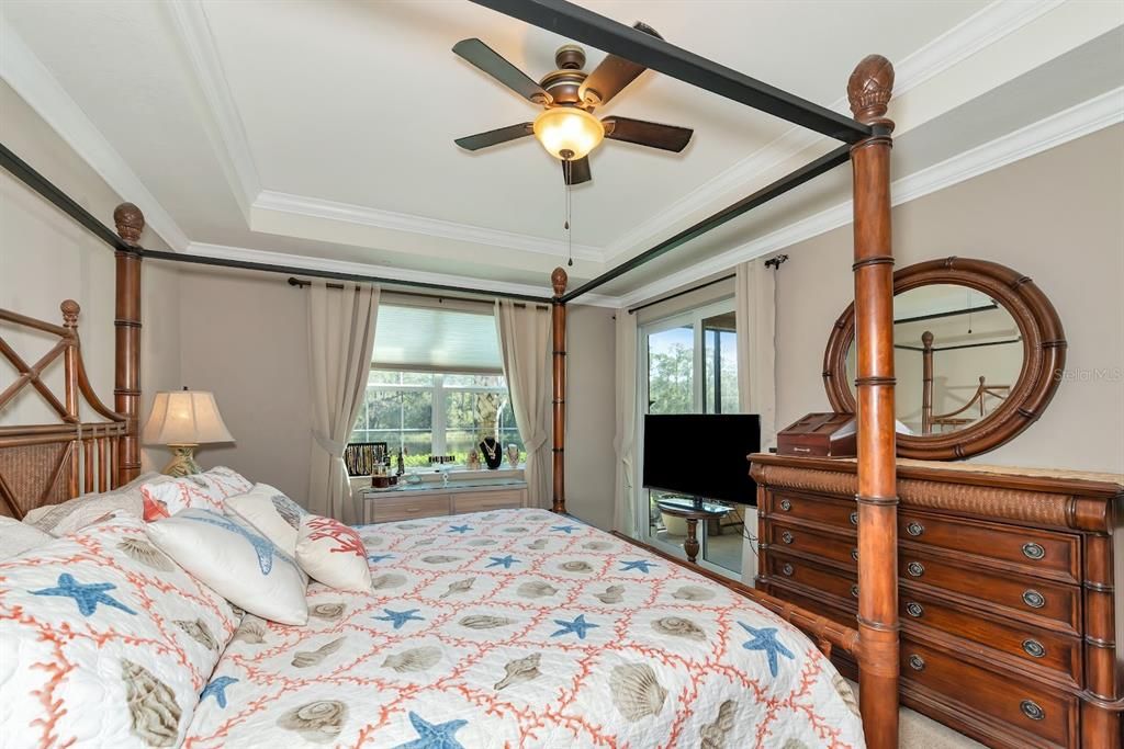 Primary Bedroom with Lake View, Tray Ceiling, and Sliding Doors Leading to the Lanai...