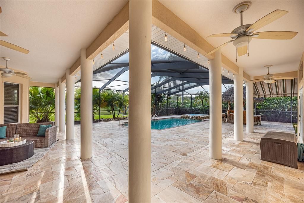 The wrap around overhang gives you flexibility to entertain outside even if the florida weather doesn't.  Travertine on the pool deck is coated with a non-skid coating.