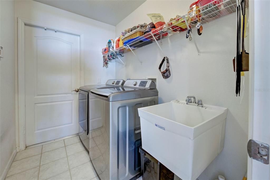 The inside laundry has shelving and opens to the garage.