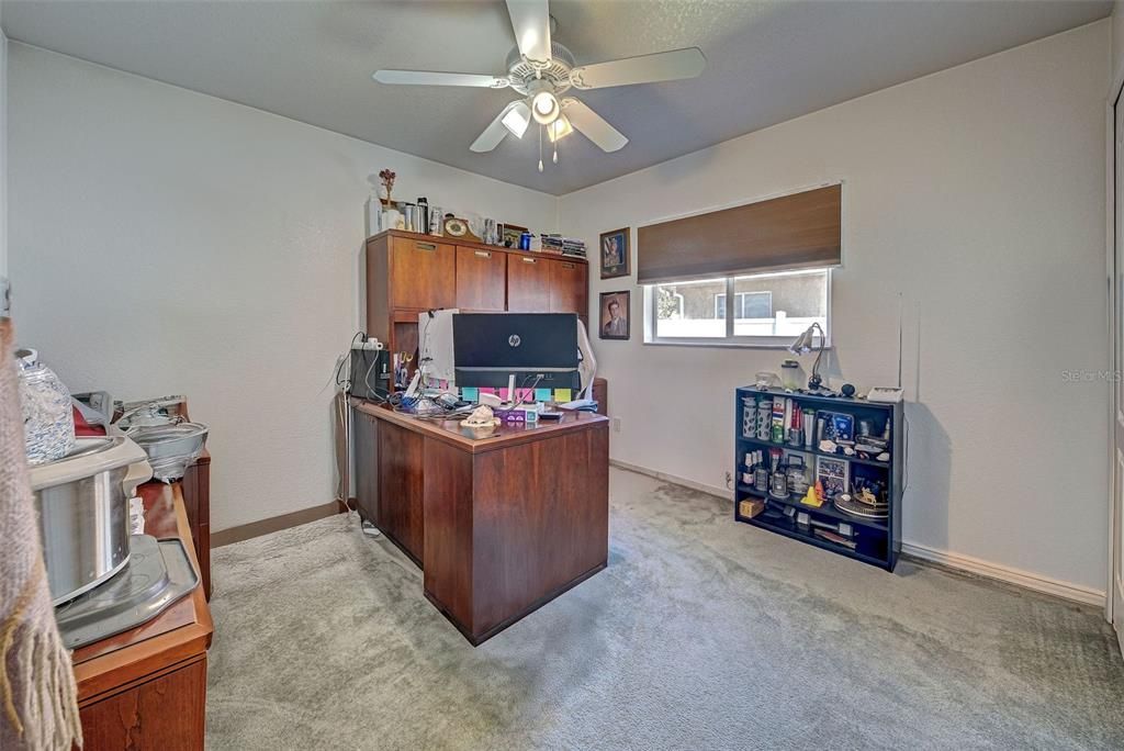 The third bedroom is carpeted and currently being used as an office.