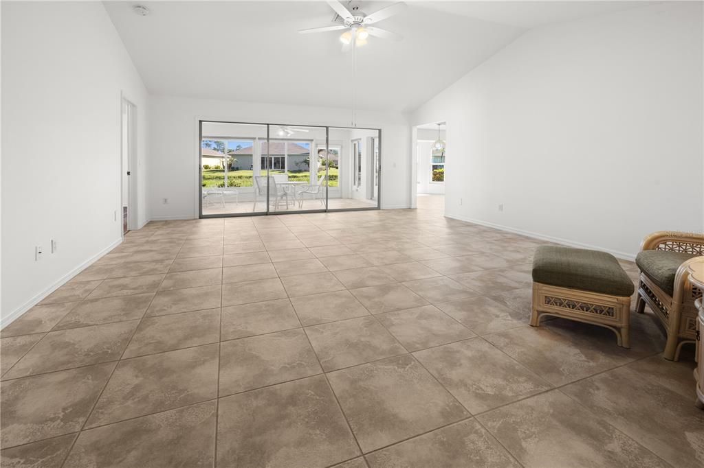 STEPPING THROUGH THE FRONT DOOR, YOU WILL FIND A SPACIOUS LIVING ROOM AND A ENCLOSED LANAI  WITH A WATER VIEW.